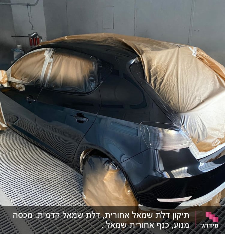 רכב מכוסה בניירות להגנה במהלך צביעת גוף הרכב